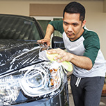 man washing car headlight